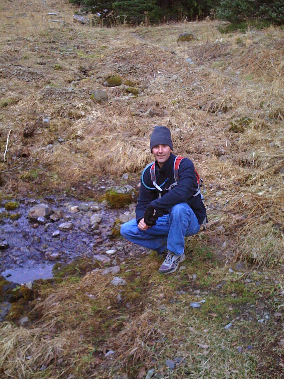 Jason kneeling at the headwaters of the Big Quilcene River
